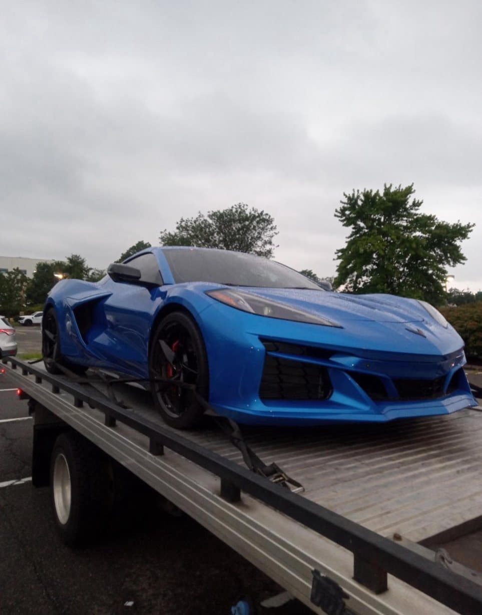 Blue Corvette secured on a Road Heroes flatbed tow truck