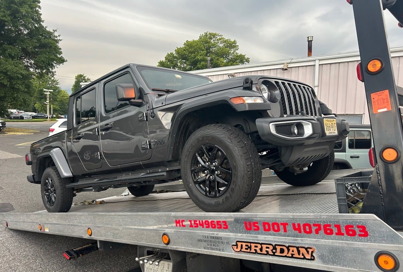 Road Heroes flatbed tow truck carrying a Jeep Gladiator in Central New Jersey
