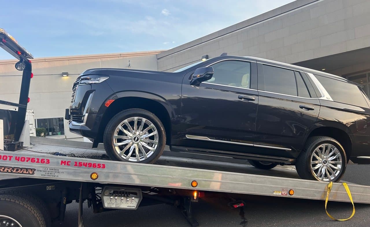 Luxury SUV secured on a Road Heroes flatbed tow truck