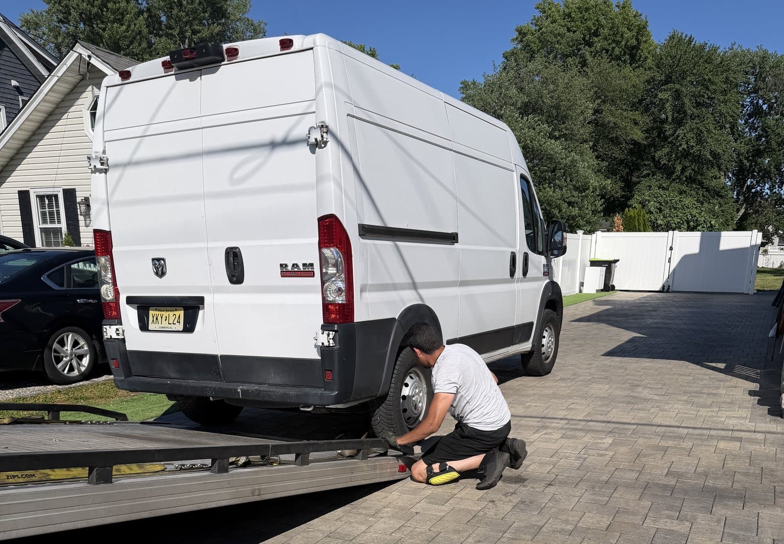 Road Heroes operator securing a Ram ProMaster van on a flatbed