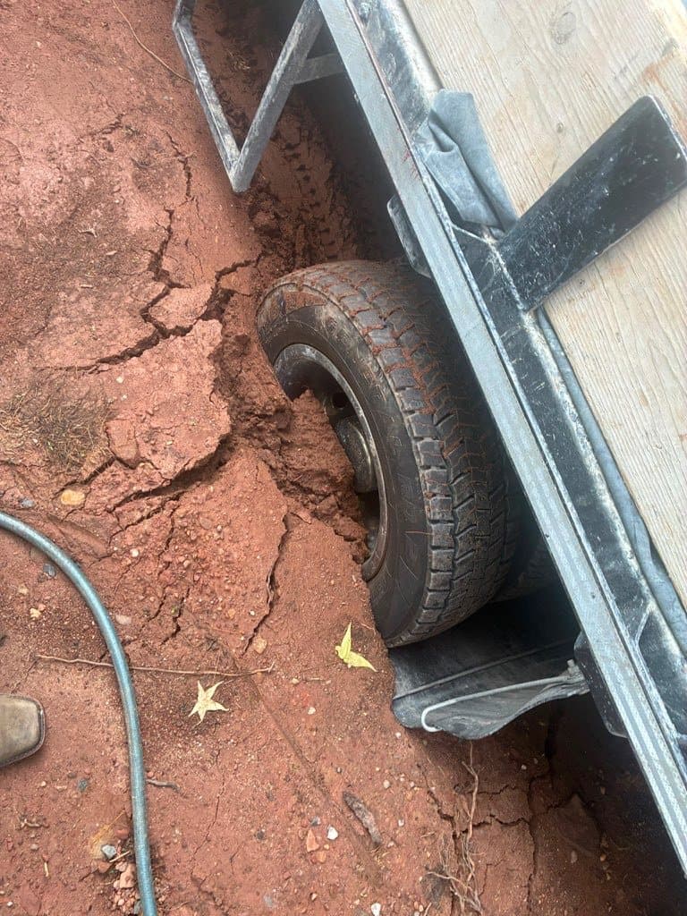 Trailer wheel stuck in mud before winch-out recovery service