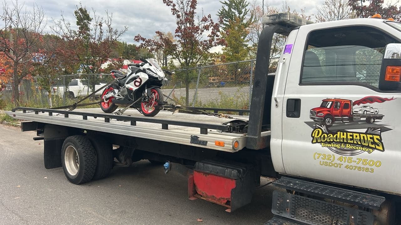 Road Heroes flatbed truck transporting a sport motorcycle safely secured